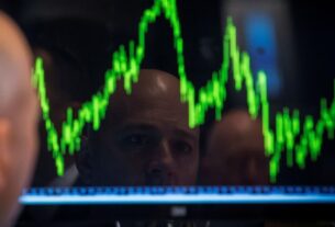 A specialist trader watches his chart while working on the floor of the New York Stock Exchange