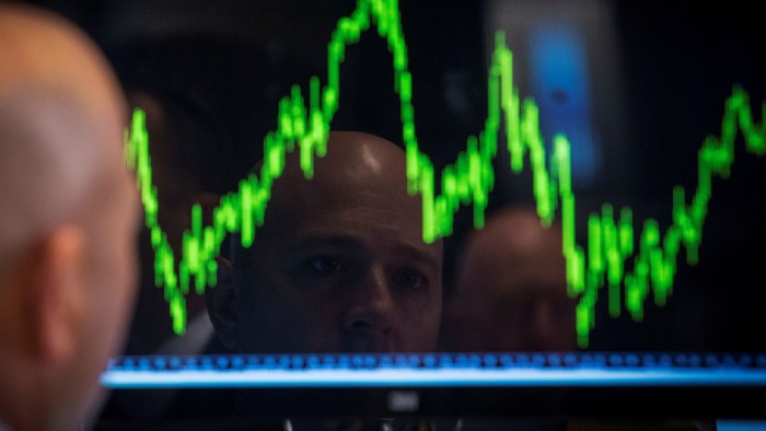 A specialist trader watches his chart while working on the floor of the New York Stock Exchange